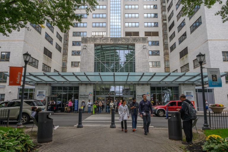 People walk toward the main entrance of Hartford Hospital.