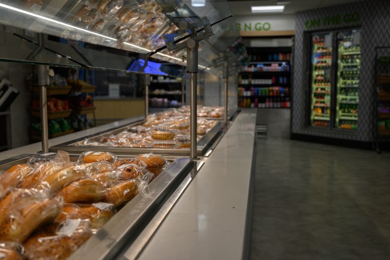 Bakery items in plastic packaging sit on a display counter in a convenience store.